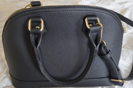medium size black purse with gold details that includes a cross-body strap