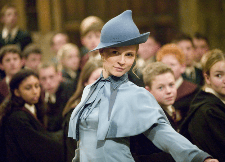 Fleur Delacour from Harry Potter wearing a light blue jacket and shrug