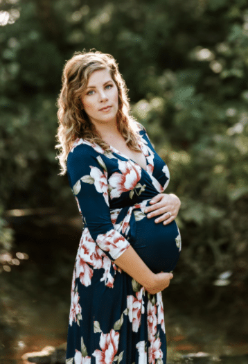 feminine maternity photo shoot dress with flowers in dark blue for outdoor fall maternity photos and maternity outfits
