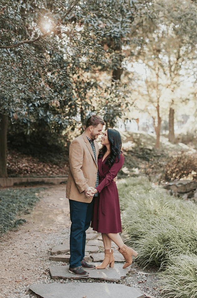 engagement photo idea for fall with a girl in a long dress and boots kissing a guy outside