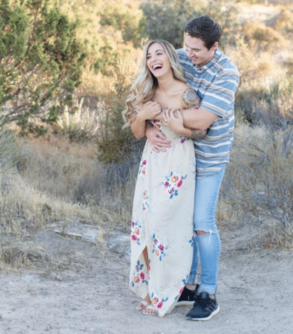 engagement photo idea for summer with woman in maxi flower print dress and man in jeans and collared shirt