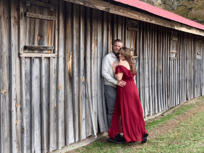 fall engagement photoshoot idea outside with red off the shoulder dress