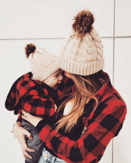 winter family picture with mom and baby in matching plaid shirts and beanie hats