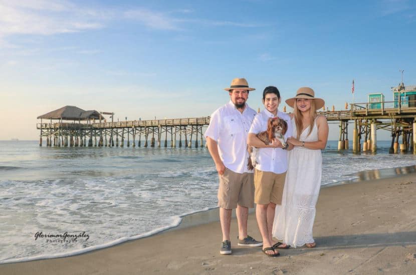 beach family photoshoot with dog, son, and white outfits