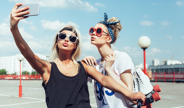 girls taking selfie on iPhone at flattering angle to avoid double chin