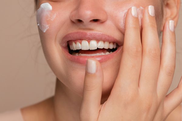 women in her 40s applying moisturizer to look younger