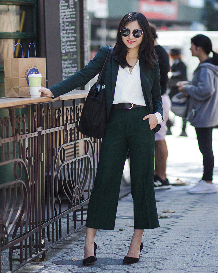 business professional outfit for women with two-piece black suit with crop pants, white blouse, and jacket