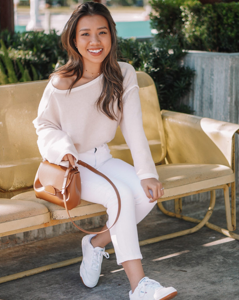 cute fall outfit idea with white capri pants, white off the shoulder sweater, white sneakers, and brown purse on Amazon