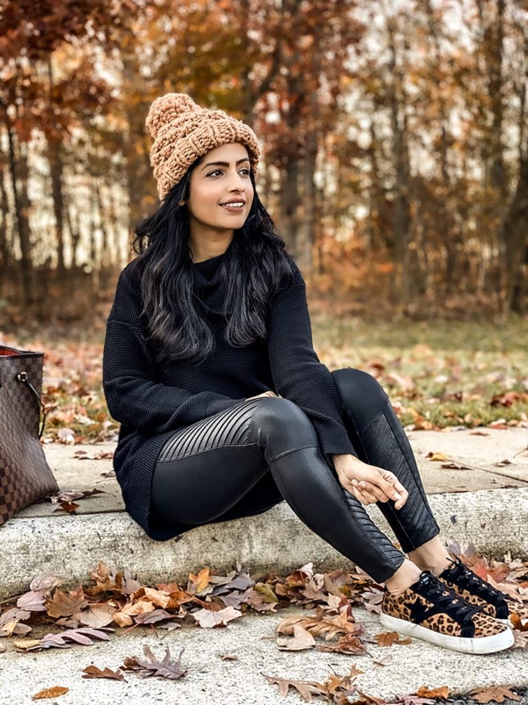 fall athleisure outfit with black tights, leopard print sneakers, and beanie hat