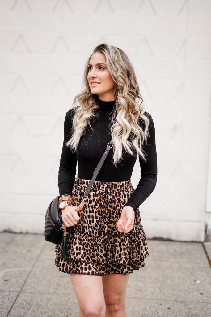 fall outfit idea with leopard print skirt, black turtleneck, and black purse on Amazon
