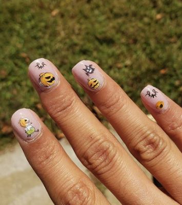Halloween nail stickers with pumpkins on light pink nail polish