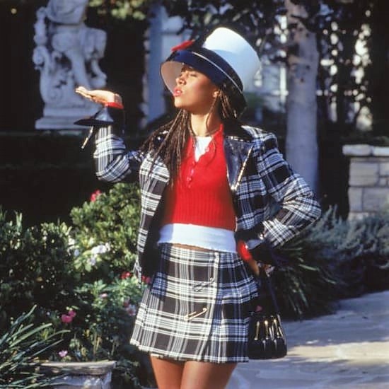 Dionne from Clueless with black purse, hat, and pleated black and white skirt