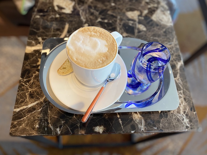 Cappuccino and water on blue plate from Holland America