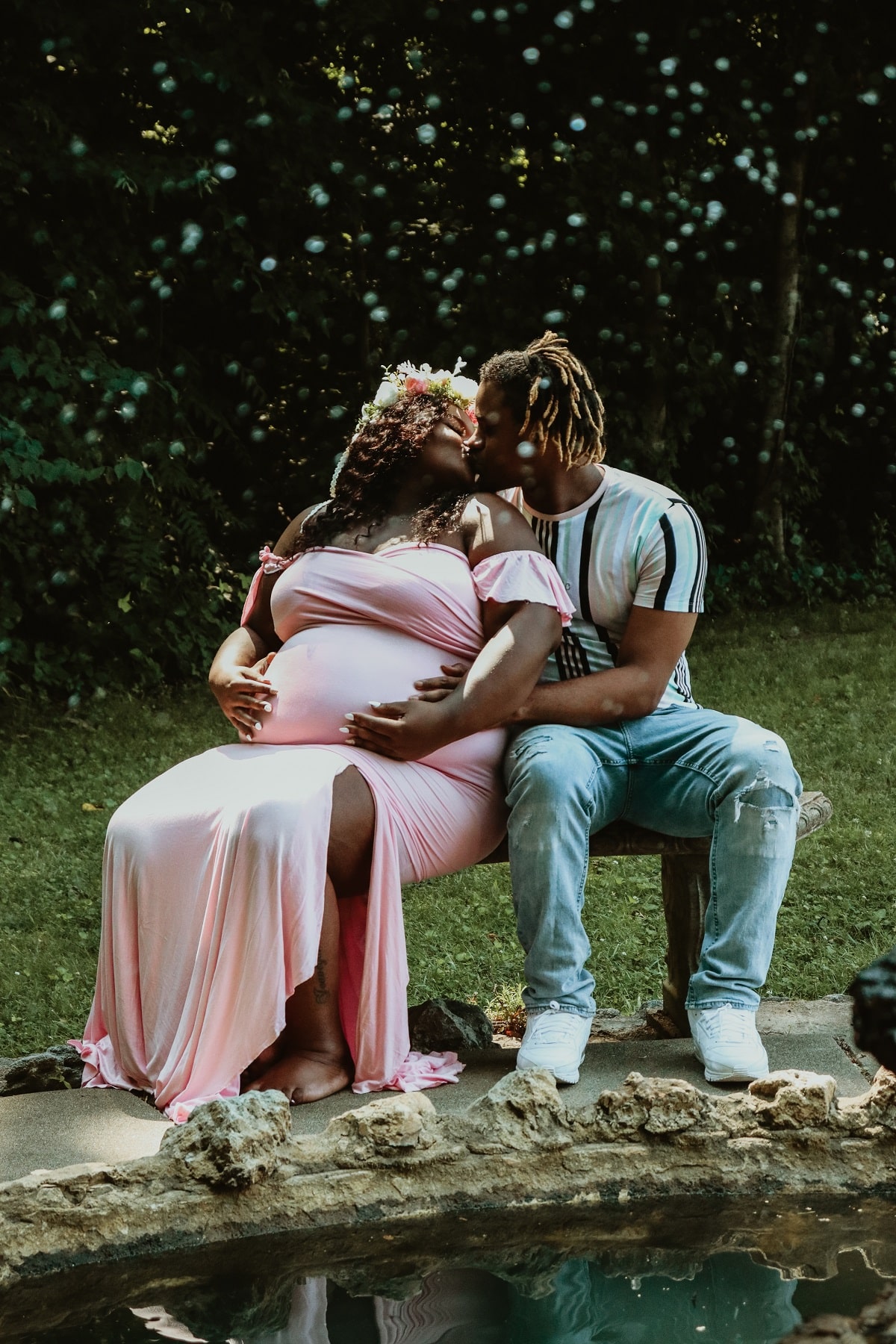 Black Couple Maternity Photoshoot on Bench in Pink Dress